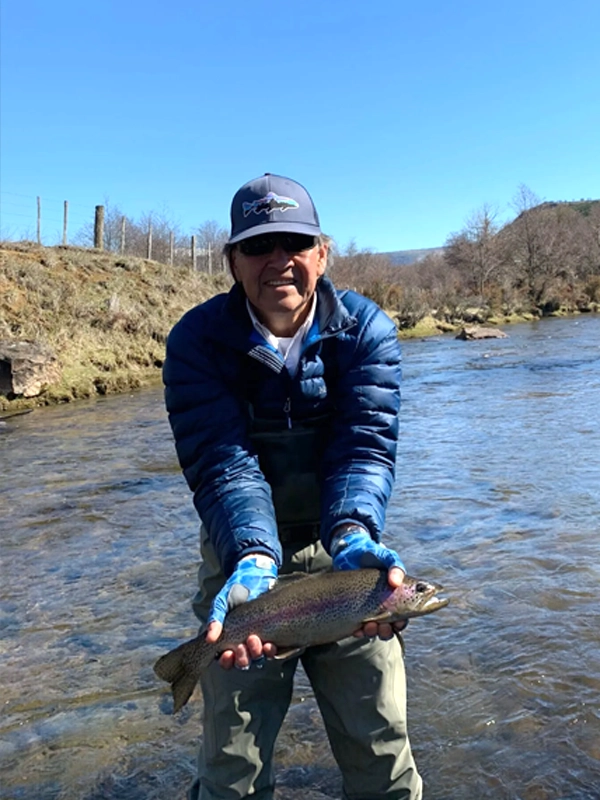 Jorge fishing in the river in Patagonia Jorge showing a fish he has just caught in the river.